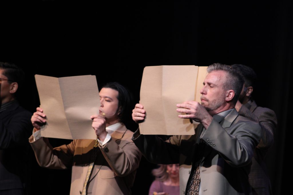 Two Office Workers mid choreo holding folders.